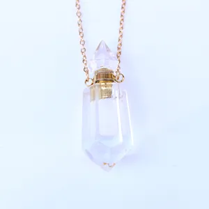 Detailweergave van de kristallen parfumfles hanger met gouden ketting en schroefdop