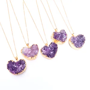 Detailoverzicht van vijf natuurlijke hartvormige amethist hangers met elegante gouden randen