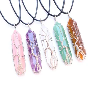 Detailed view of Tree of Life crystal pendants in amethyst and quartz with silver wire wrap