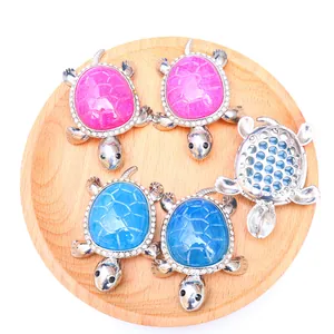 Close-up of tortoise agate pendants with sparkling crystal border on a wooden tray