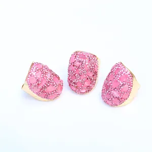 Detailansicht von drei Goldringen mit rosa Kristallclustern und Mikro-Pavé-Fassung