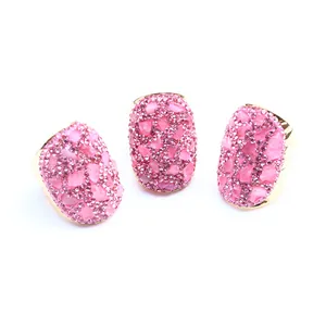 Detaillierte Ansicht von drei Goldringen mit ovalen Flächen, rosa Kristallen und Rosenquarz