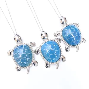Three sea turtle necklaces with blue gemstones and sparkling crystals on silver chains