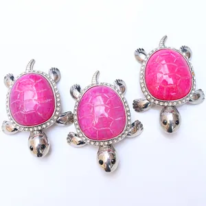 Detail of rose pink agate turtle pendants with silver alloy and sparkling crystal accents