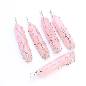 Close-up of five rose quartz hexagonal prisms wrapped in silver tree of life wire art