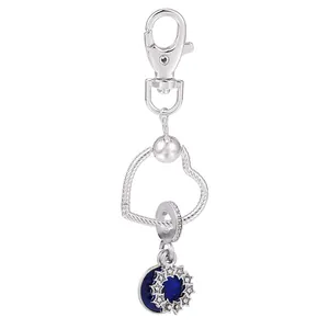 Vue détaillée du porte-clés argenté avec anneau coeur et pendentif étoile bleue