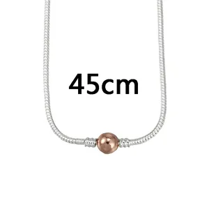 Détail d'un collier chaîne serpent argentée de 45cm avec perle décorative rose doré