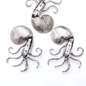 Detail of silver alloy octopus brooches showing pin clasp and brown spotted texture