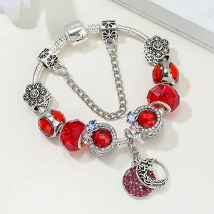 Détail du bracelet chaîne serpent avec perles en verre rouge et pendentif en cristal