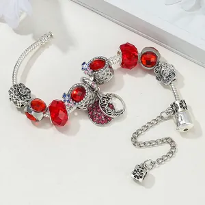 Vue détaillée d'un bracelet serpent avec perles en cristal rouge et breloques