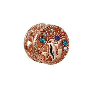 Macro d'une perle en or rose avec motif de poisson tropical et cristaux colorés