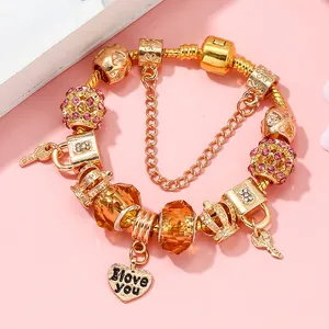 Goldenes Charm-Armband mit Kronen- und Herzanhängern sowie rosa Strasssteinen