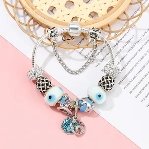 Silver charm bracelet with blue beads, earth charm and ocean pendant on stylish background