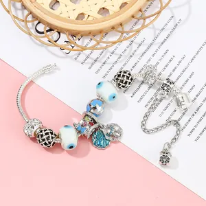 Silver charm bracelet featuring blue evil eye beads and enamel sea life pendants