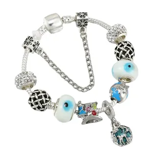 Silver charm bracelet featuring blue camellia beads and forest deer pendant on white background