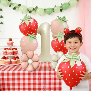 First birthday party set with strawberry balloons and large number 1 foil balloon