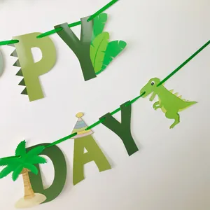 Détail de la bannière Happy Birthday dinosaure vert avec palmiers et dessins