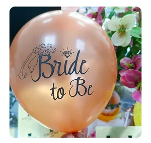 Close-up of rose gold latex balloon with black Bride to Be text and diamond ring detail