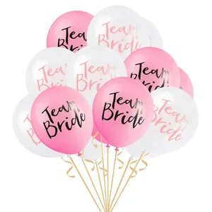 Close-up of pink and white Team Bride latex balloons with gold ribbons for wedding parties