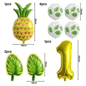 Détail du set de fête Hawaï avec ballons ananas, chiffre un doré et feuilles de palmier