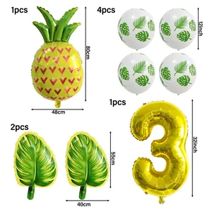 Détail du set de fête tropicale avec ballons ananas, chiffre 3 et feuilles