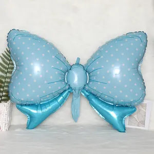 Macro shot of a light blue bow foil balloon with white polka dots on a plush white rug