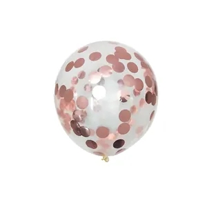 Macro view of transparent party balloon filled with rose gold metallic confetti