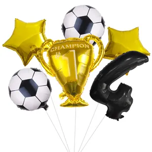 Detail of football party kit with champion trophy, number 4, and star foil balloons