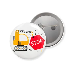 Detail view of traffic-themed tinplate badges showing front design and back safety pin