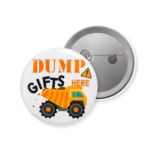 Macro view of tinplate badge showing front dump truck print and back safety pin detail