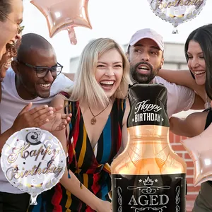 Dettaglio di palloncini a forma di bottiglia di champagne e stelle per festa di compleanno