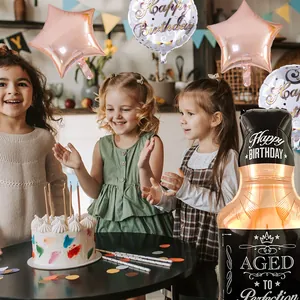 Bambini che festeggiano con palloncini a stella d'oro e bottiglia di whisky