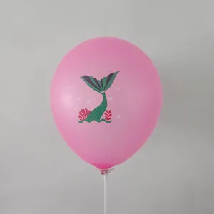 Detail of pink mermaid balloon featuring printed sea shells and plants on a plastic stand