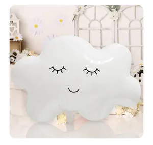 Close-up of white cloud-shaped foil balloon with smiling face for party decoration