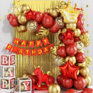 Dettaglio del kit compleanno rosso e oro con nappe lucide e palloncini corona in alluminio