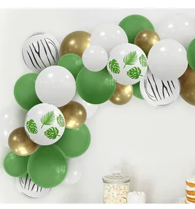 Detail of forest theme balloon arch with monstera leaves and gold latex balloons