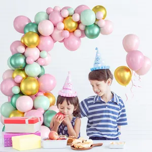 Détail du kit arche de ballons rose pastel et or avec chapeaux de fête Prince et Princess