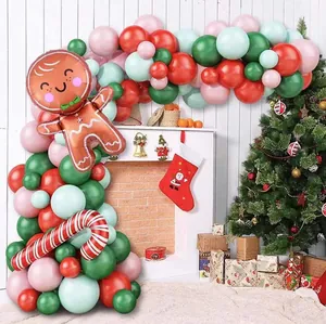 Christmas balloon arch with gingerbread man and candy cane foil balloons by a fireplace