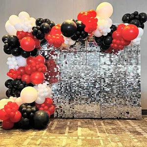 Dettaglio del muro luccicante argento con palloncini decorativi rossi, neri e bianchi