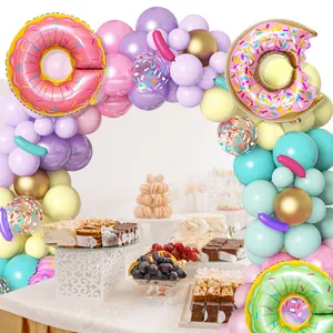 Macro view of donut theme balloon arch kit with pink foil donuts for birthday parties