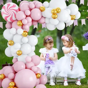 Outdoor pink and gold balloon arch kit with candy foil balloon for a girls party setup