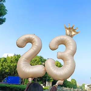 Detail of 40-inch champagne gold number balloon with crown for birthday celebration