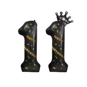 Détail de ballons numéro 11 noirs avec inscription dorée happy birthday et couronne