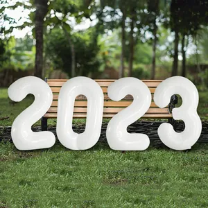 Close-up of white 2023 foil number balloons on a park bench for New Year party decoration