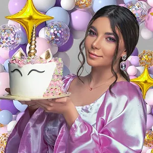 Unicorn themed birthday party setup with rainbow balloons and decorative party cake