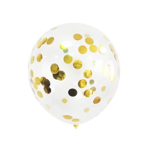 Close-up of clear party balloon filled with shiny gold round confetti on white background