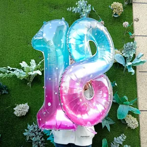 Détail de ballons chiffres de 40 pouces dégradés bleu et rose sur fond d'herbe verte