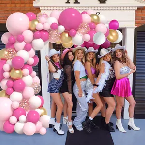 Arche de ballons rose et doré avec des femmes posant à l'entrée d'une fête festive