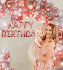 Détail de guirlande de ballons d'anniversaire or rose avec confettis et lettres en métal