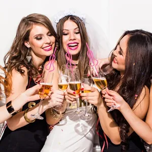 Close-up of three women holding glasses with funny pink bride-to-be straws for hen party